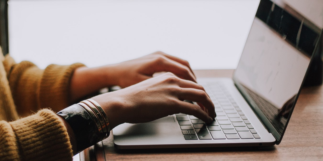 Photo of a woman typing on her Mac